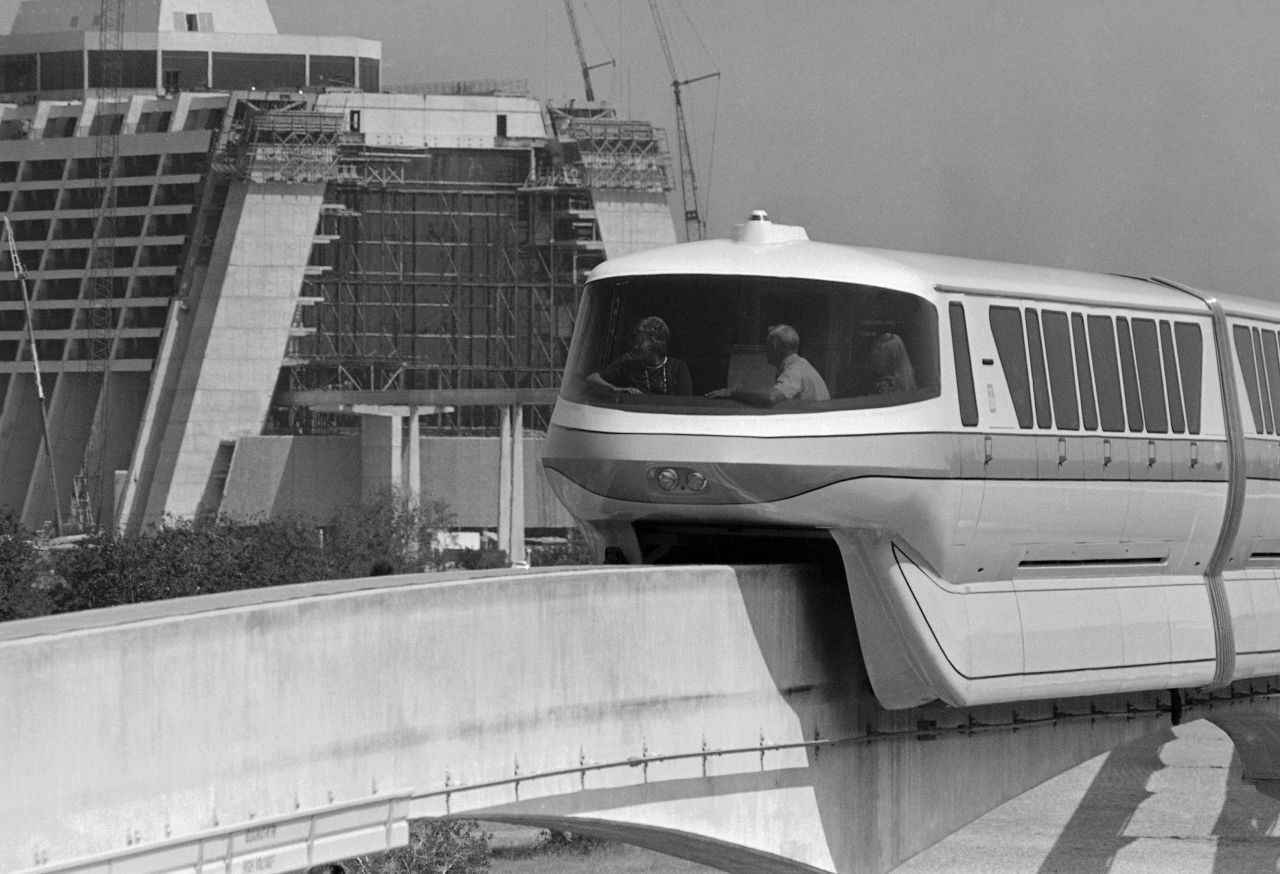 A family rides into Disney World aboard a monorail train circling the resort in October 1971. The Contemporary Resort in the background was still unfinished.