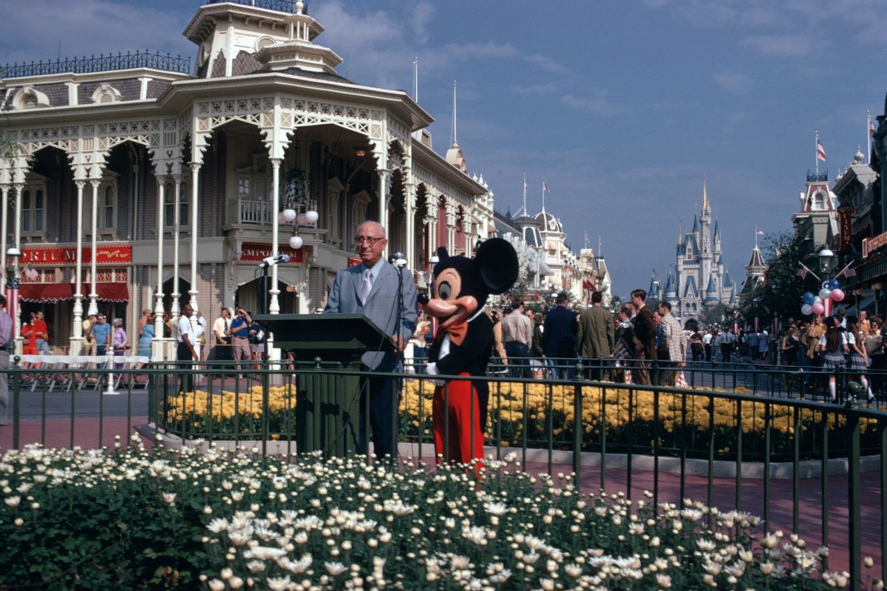 Roy O. Disney, Walt Disney's brother, joins Mickey Mouse for the dedication ceremony in 1971. Walt Disney had died in 1966. "May Walt Disney World bring joy and inspiration and new knowledge to all who come to this happy place ... a Magic Kingdom where the young at heart of all ages can laugh and play and learn together," Roy said.