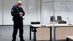 A judicial officer looks at his watch prior to a trail against a 96-year-old former secretary for the SS commander of the Stutthof concentration camp at the court room in Itzehoe, Germany, Thursday, Sept. 30, 2021.