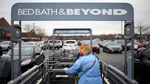 A customer wearing a protective mask retrieves a shopping cart outside a Bed Bath & Beyond store in Louisville, Kentucky, U.S., on Saturday, January 2, 2021. 