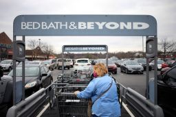 A customer wearing a protective mask retrieves a shopping cart outside a Bed Bath & Beyond store in Louisville, Kentucky, U.S., on Saturday, Jan. 2, 2021. 