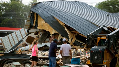 People watch cleanup efforts after buildings were destroyed by flooding in August in Waverly, Tennessee.