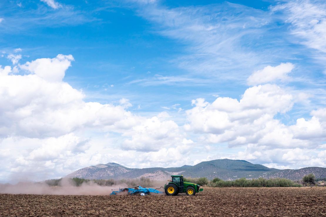 A tractor tears through dry dirt on land that was unplanted this year due to water shortages in Tulelake, California. This summer for the first time, hundreds of farmers along the California-Oregon border who rely on irrigation from Klamath Lake are not getting any water from it.