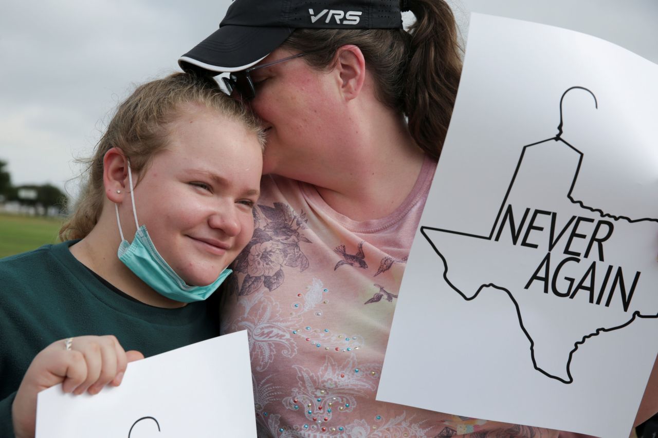 Laura Woodward and her daughter Isabel participate in a march in Frisco, Texas.
