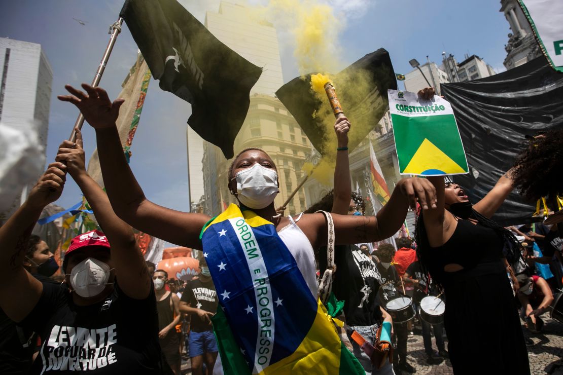 A woman, wrapped in a Brazilian national flag, chants slogans during a protest against Brazilian President Jair Bolsonaro on Saturday, October 2. 
