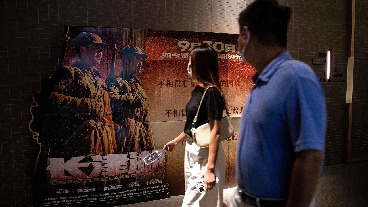 Movie goers passing in front of a poster for "The Battle At Lake Changjin" in a cinema in Wuhan, China. 