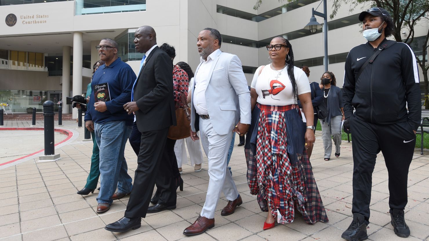 Attorney Ben Crump, second from left, walks with Ron Lacks, left, Alfred Lacks Carter, third from left, both grandsons of Henrietta Lacks, and other descendants of Lacks, whose cells have been used in medical research without her permission, outside the federal courthouse in Baltimore on Monday.