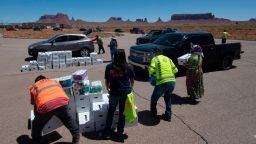 Navajo Nation volunteers deliver drinking water and food to families in need outside Monument Valley Tribal Park, which has been closed due to the Covid-19 pandemic in Arizona on May 21, 2020. - Weeks of delays in delivering vital coronavirus aid to Native American tribes exacerbated the outbreak, the president of the hard-hit Navajo Nation said, lashing the administration of President Donald Trump for botching its response. (Photo by MARK RALSTON/AFP via Getty Images)