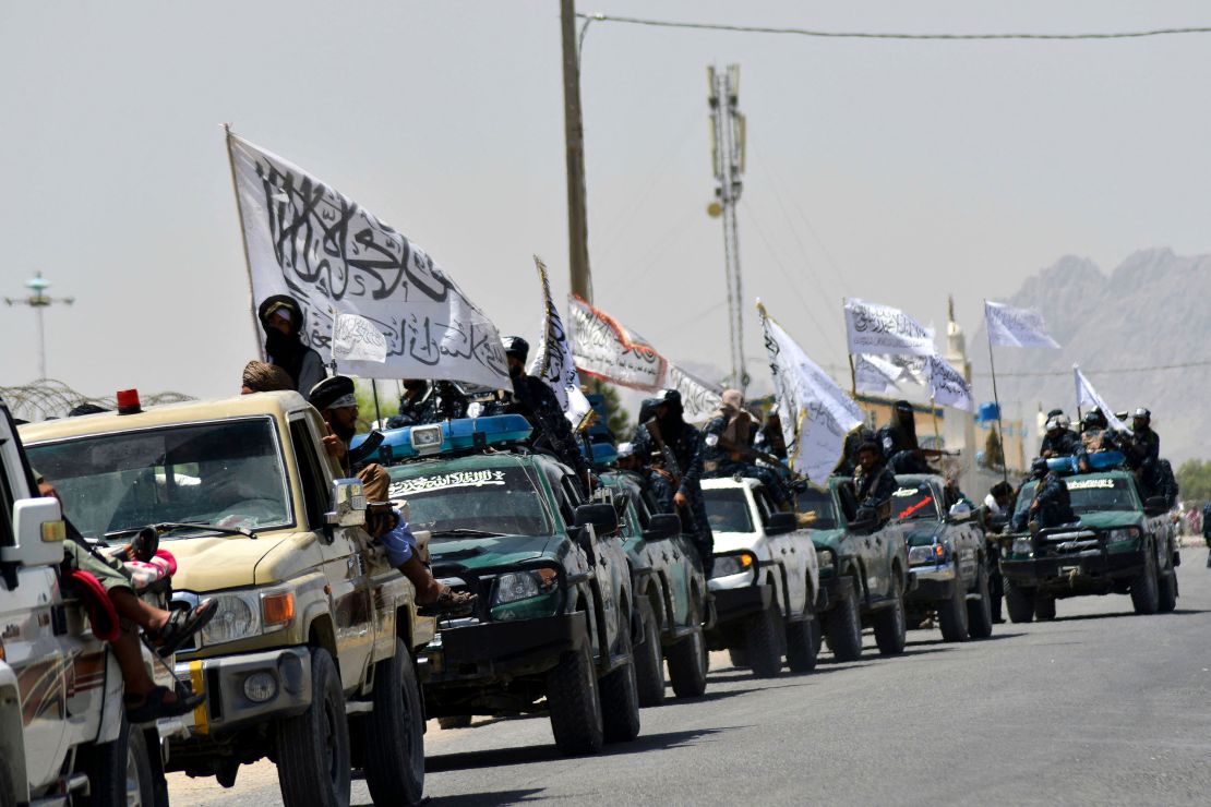 Taliban fighters atop vehicles with Taliban flags parade along a road to celebrate after the US pulled all its troops out of Afghanistan, in Kandahar on September 1.