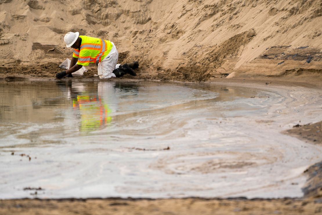 Crews work to clean the oil from the area in Huntington Beach.