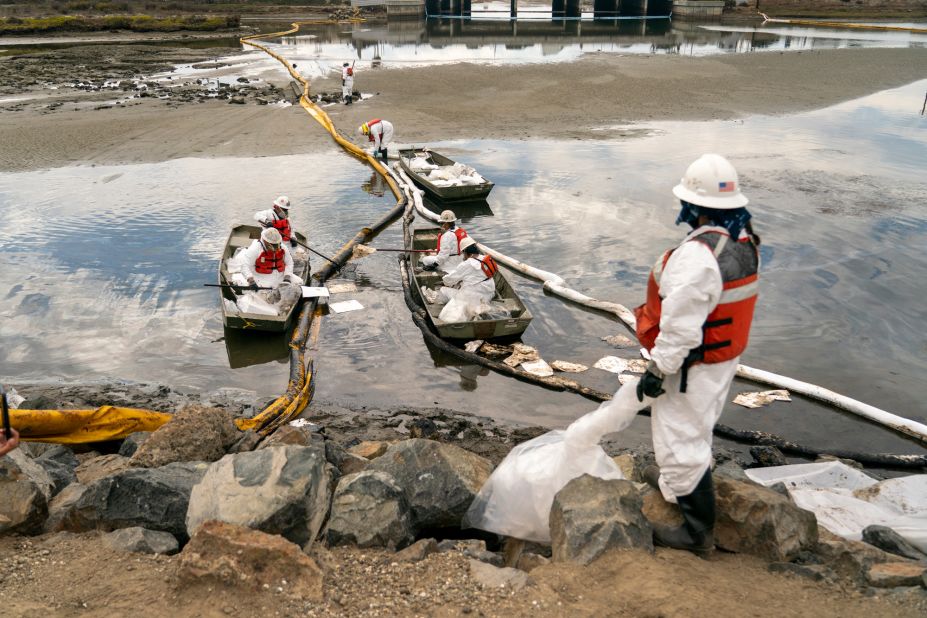 Workers with Patriot Environmental Services clean up some of the oil that flowed into the Talbert Marsh.