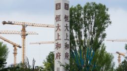 Cranes stand near Evergrande's name and logo at a new housing development in Beijing.