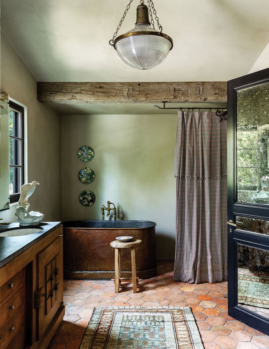 A 19th-century copper bathtub is the centerpiece to this stripped-back bathroom.