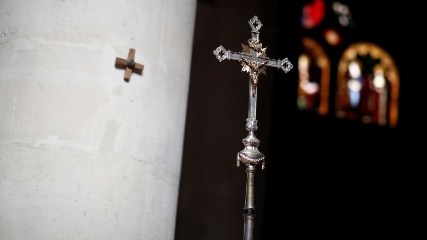 A priest carries a cross during the annual procession of the Station of the Cross on Good Friday preceding Easter Celebrations at the Catholic Church of Saint-Germain l'Auxerrois as the spread of the coronavirus disease (COVID-19) continues, in Paris, France April 10, 2020. REUTERS/Benoit Tessier