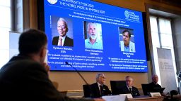 Goran K. Hansson (C), Secretary General of the Royal Swedish Academy of Sciences, and members of the Nobel Committee for Physics Thors Hans Hansson (L) and John Wettlaufer (R) sit in front of a screen displaying the co-winners of the 2021 Nobel Prize in Physics (L-R) Syukuro Manabe (US-Japan), Klaus Hasselmann (Germany) and Giorgio Parisi (Italy) at the Royal Swedish Academy of Sciences in Stockholm, Sweden, on October 5, 2021. - US-Japanese scientist Syukuro Manabe, Klaus Hasselmann of Germany and Giorgio Parisi of Italy won the Nobel Physics Prize for climate models and the understanding of physical systems, the jury said. Manabe and Hasselmann share one half of the prize for their research on climate models, while Parisi won the other half for his work on the interplay of disorder and fluctuations in physical systems. (Photo by Jonathan NACKSTRAND / AFP) (Photo by JONATHAN NACKSTRAND/AFP via Getty Images)