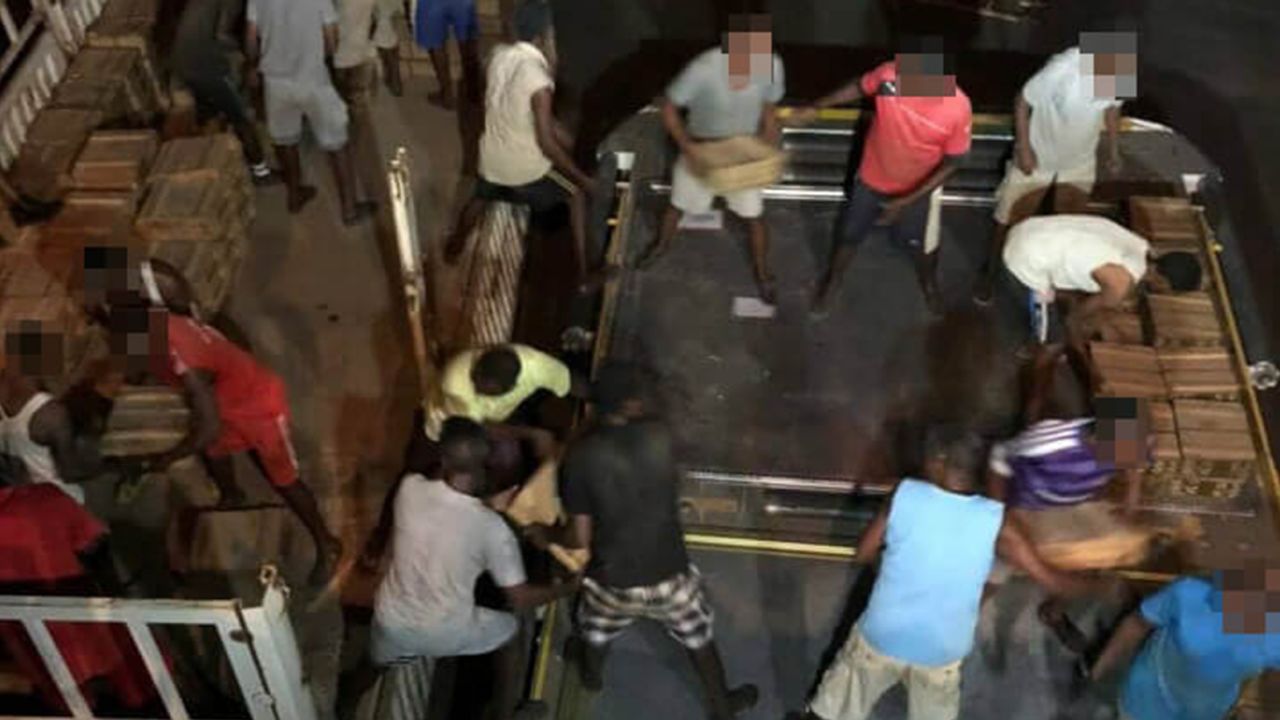 People are seen loading crates of weapons onto an Ethiopian Airlines plane at an airport in Massawa, Eritrea. Some faces have been blurred by CNN to preserve anonymity.