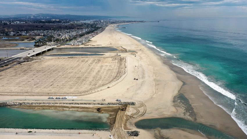 HUNTINGTON BEACH, CALIFORNIA - OCTOBER 04: In an aerial view, crews reinforce a sand berm (BOTTOM-C) blocking oil in the ocean from entering an inlet leading to the Talbert Marsh wetlands after a 126,000-gallon oil spill from an offshore oil platform on October 4, 2021 in Huntington Beach, California. The spill forced the closure of the popular Great Pacific Airshow yesterday with authorities closing beaches in the vicinity.  (Photo by Mario Tama/Getty Images)