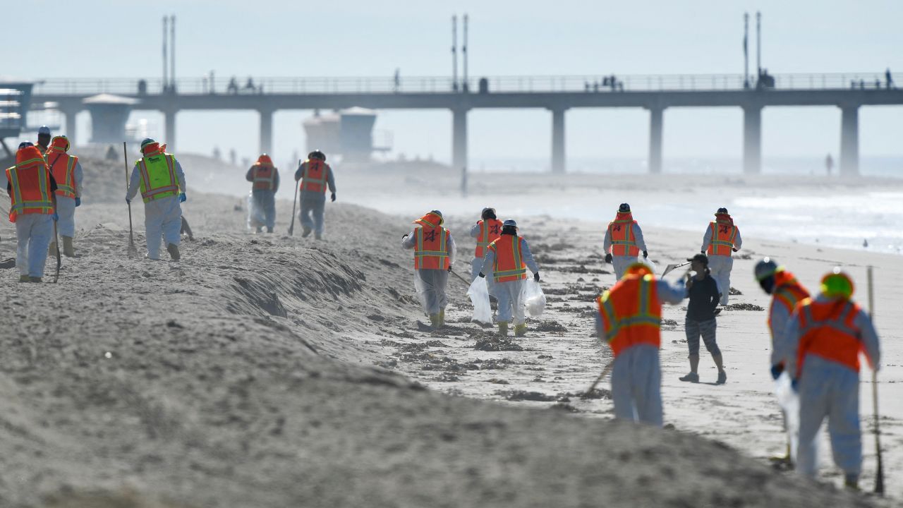 Workers clean up debris in Huntington Beach on October 5.