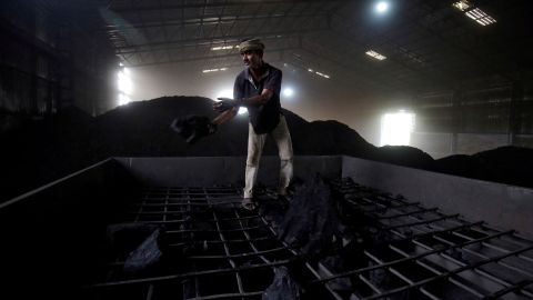 A laborer works inside a coal yard on the outskirts of Ahmedabad, India, in 2017.