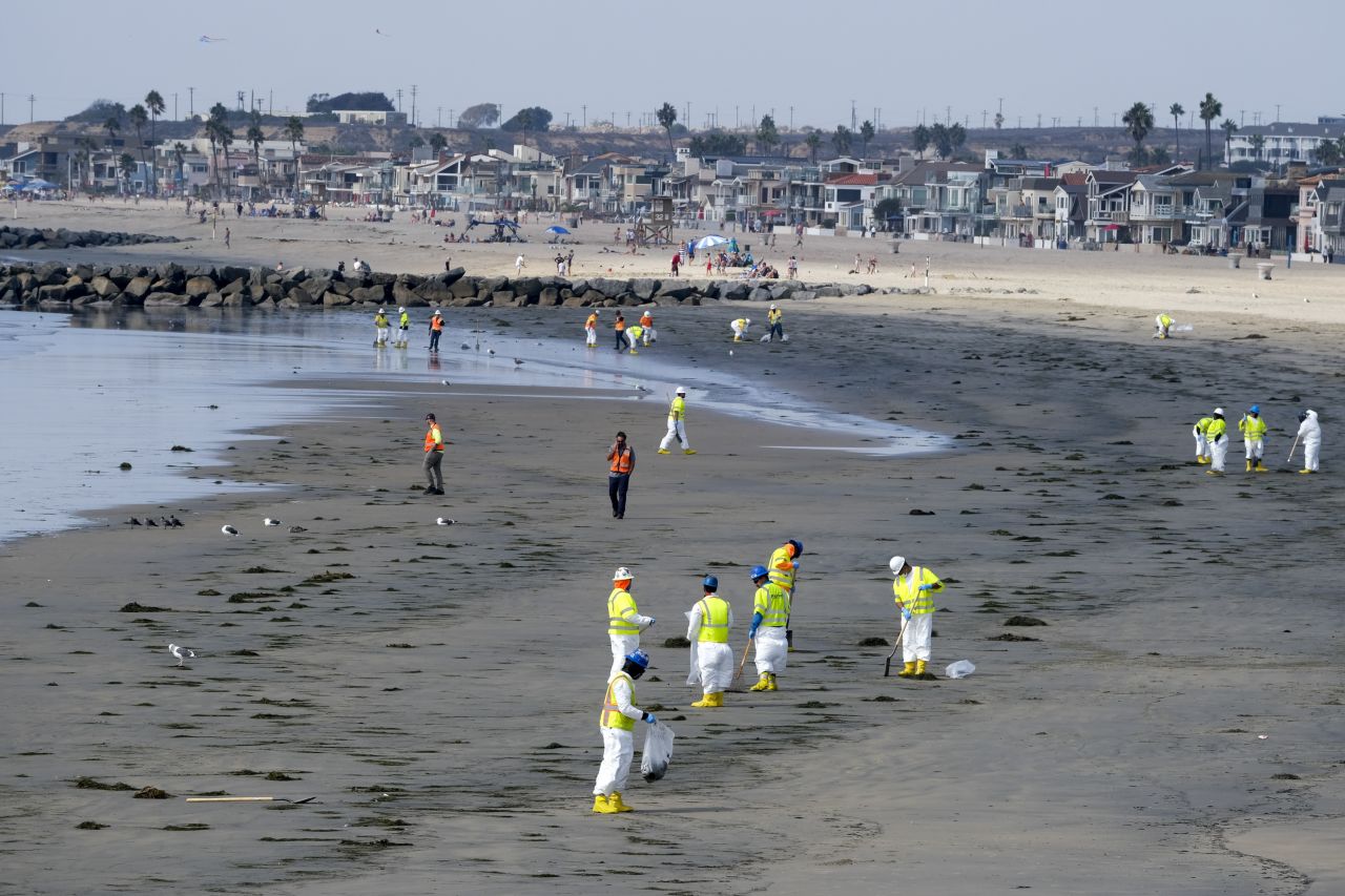 Workers clean a contaminated area of Newport Beach on October 6.
