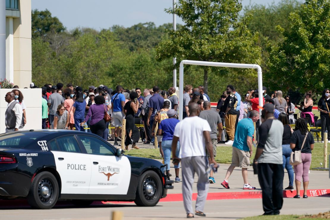 Families outside the Mansfield ISD Center for the Performing Arts waiti to be reunited with their children.