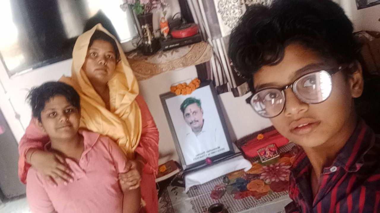 Pooja Sharma and her children at home in front of a photo of her late husband, who died of Covid-19 in April in Delhi, India.