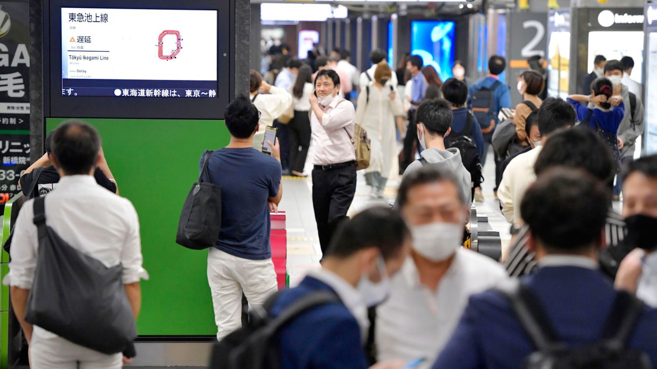 The entrance of JR Shimbashi station in Tokyo is crowded with passengers as the train services are suspended following an earthquake on Thursday.