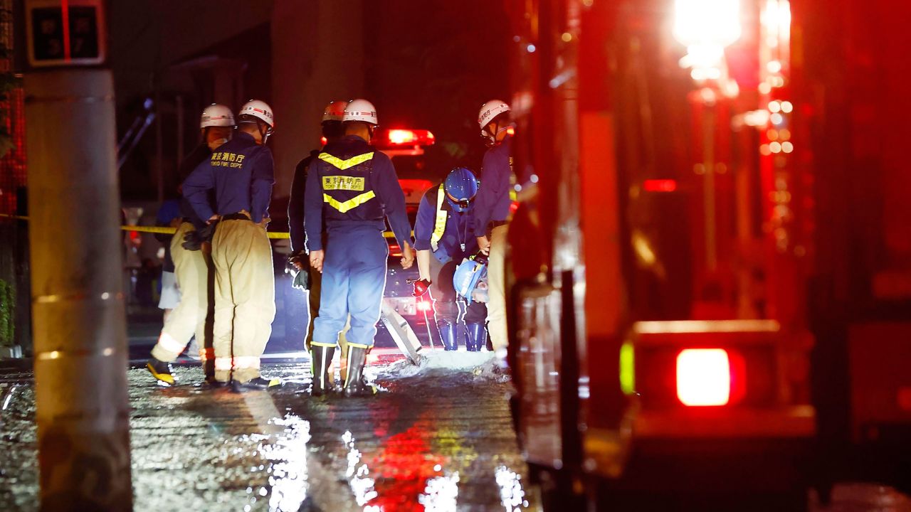Firefighters work on an inundated road following the quake. 