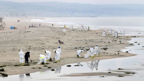 A cleanup crew works on the beach on October 7 in Newport Beach. 