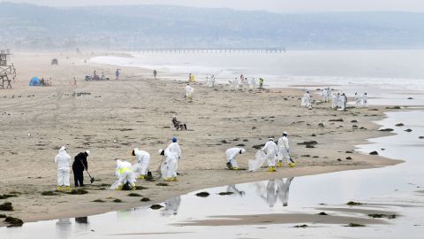 A cleanup crew works on the beach on October 7 in Newport Beach.