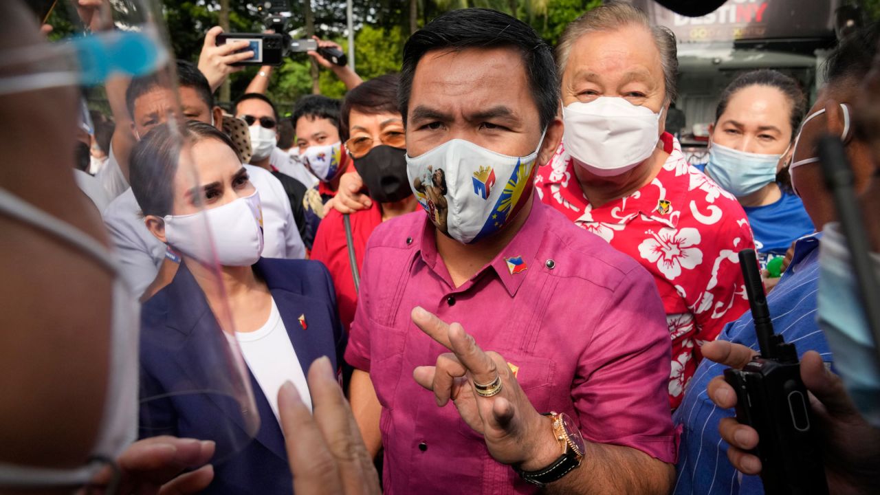 Retired Filipino boxing hero and senator Manny Pacquiao, center, talks to police beside wife Jinkee, left, before filing his certificate of candidacy on October 1 in Manila.