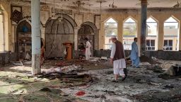 People inspect the inside of a mosque following a bombing in Kunduz province northern Afghanistan, Friday, Oct. 8, 2021. A powerful explosion in the mosque frequented by a Muslim religious minority in northern Afghanistan on Friday has left several casualties, witnesses and the Taliban's spokesman said. (AP Photo/Abdullah Sahil)