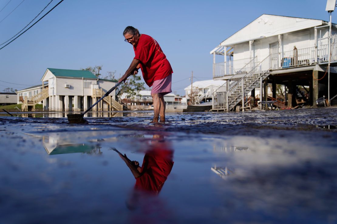 Cindy Rojas cleans mud and floodwater from her driveway in Lafitte, Louisiana, in the aftermath of Hurricane Ida in September.