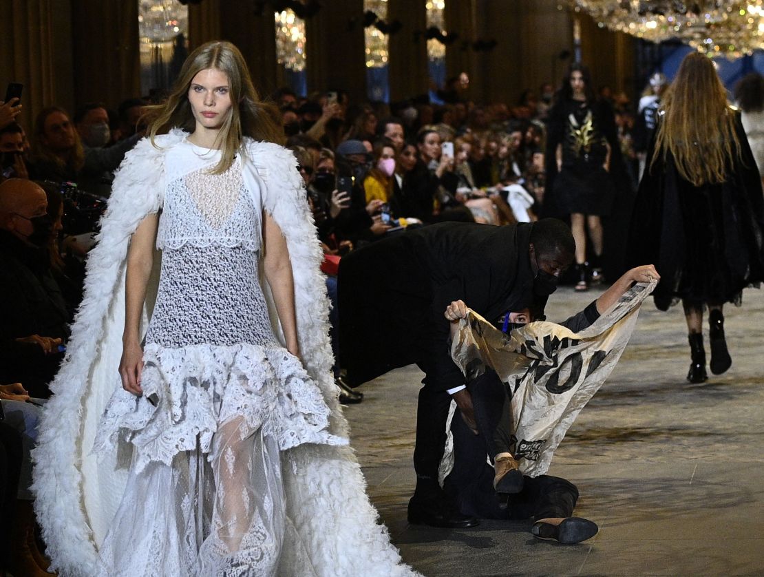A demonstrator is evicted by a security member at the Louis Vuitton show. 