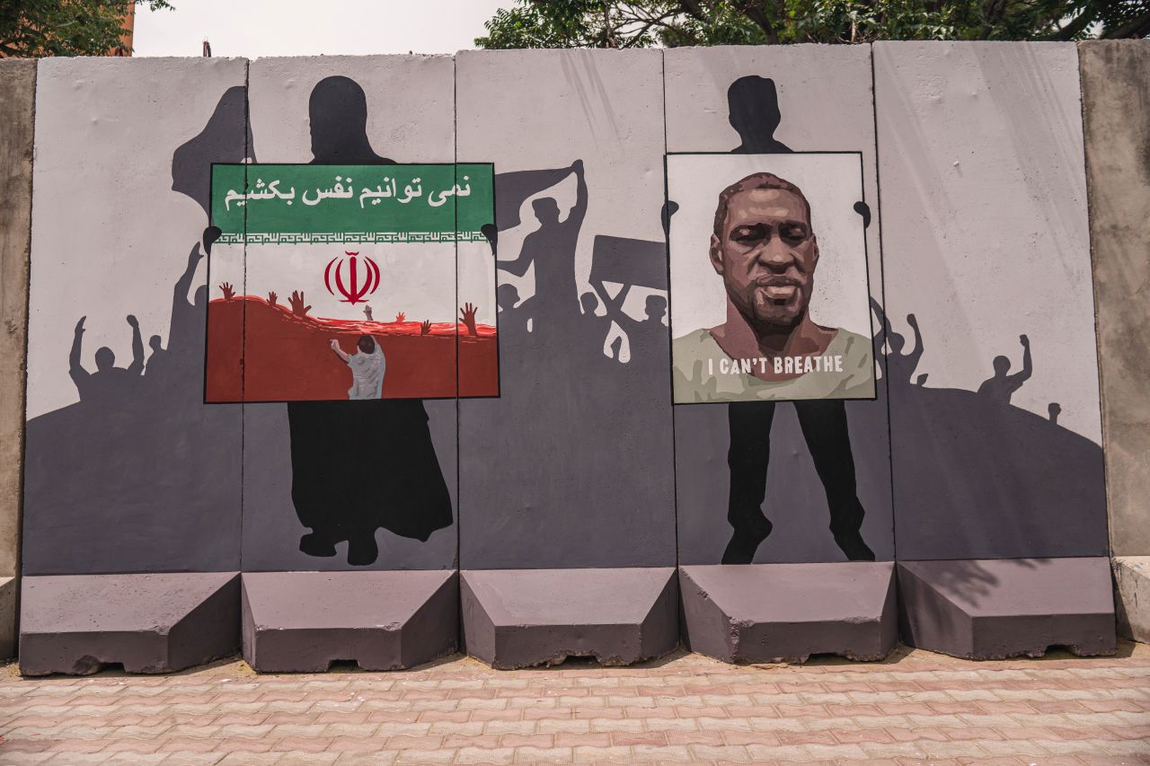 A mural honors the killing of George Floyd and Afghan refugees allegedly drowned in Iran reads "we can't breathe".