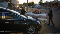 Jorge Ortiz, general manager of Perches Funeral Homes,  pushes a casket to a hearse with Assistant Funeral Director Gabriel Tavarez (L) at Perches Funeral Home in El Paso, Texas, on December 4, 2020.
