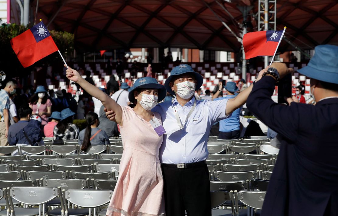 A couple take a photo with Taiwan national flags during National Day celebrations in front of the Presidential Building in Taipei, Taiwan.