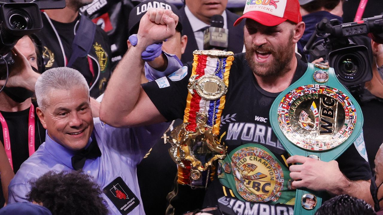 Referee Russell Mora holds up the arm of Fury as he celebrates his victory over Wilder