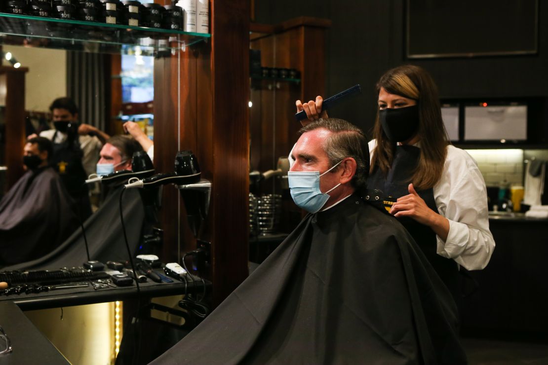 NSW Premier Dominic Perrottet receives a haircut on October 11, following the easing of Covid-19 restrictions in the state.