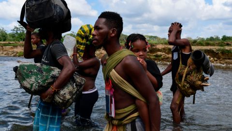 TOPSHOT - Migrants cross the Chucunaque river after walking for five days in the Darien Gap, in Bajo Chiquito village, Darien province, Panama on February 10, 2021, on their way to the US. - Migrants from Haiti and several African countries remain stranded at the Panama-Colombia border, while the Central American country is expecting a new wave of migrants. (Photo by Luis ACOSTA / AFP) (Photo by LUIS ACOSTA/AFP via Getty Images)