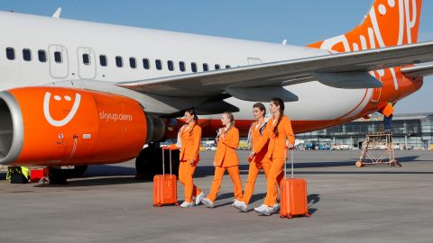 Flight attendants of SkyUp Airlines walk along a tarmac during the presentation of a new uniform at the Boryspil International Airport outside Kyiv, Ukraine September 30, 2021. The Ukrainian low-cost airline presented their innovative uniform, including loose costumes and sneakers, for the crew to feel comfortable and look fashionable during the flights. Picture taken September 30, 2021. REUTERS/Gleb Garanich