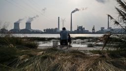 An angler is seen fishing along the Huangpu river across the Wujing Coal-Electricity Power Station in Shanghai on September 28, 2021. 