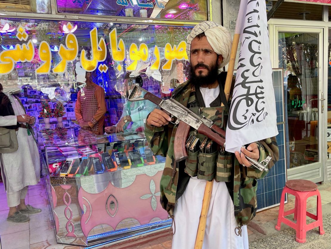 A Taliban fighter waits outside an electronics shop in Ghazni.