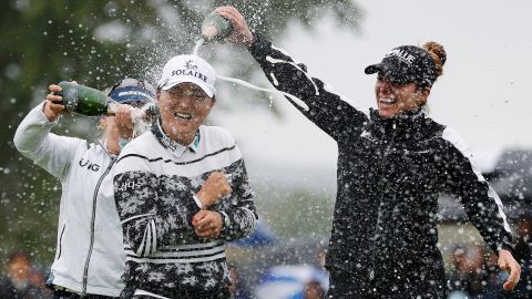 Gabby Lopez (right) and Brooke Henderson (left) pour champagne on Ko after her win at the Founders Cup at Mountain Ridge Country Club.