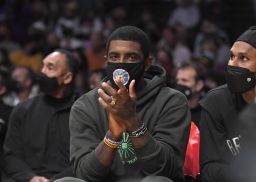 Kyrie Irving cheers from the bench during a preseason game against the Los Angeles Lakers, Oct. 3, 2021, in Los Angeles.