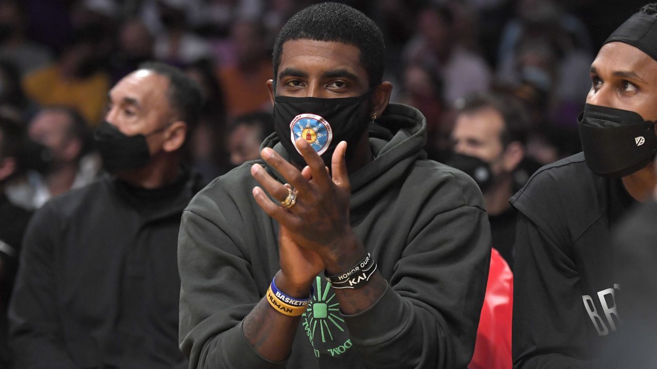 Kyrie Irving cheers from the bench during a preseason game against the Los Angeles Lakers, Oct. 3, 2021, in Los Angeles.
