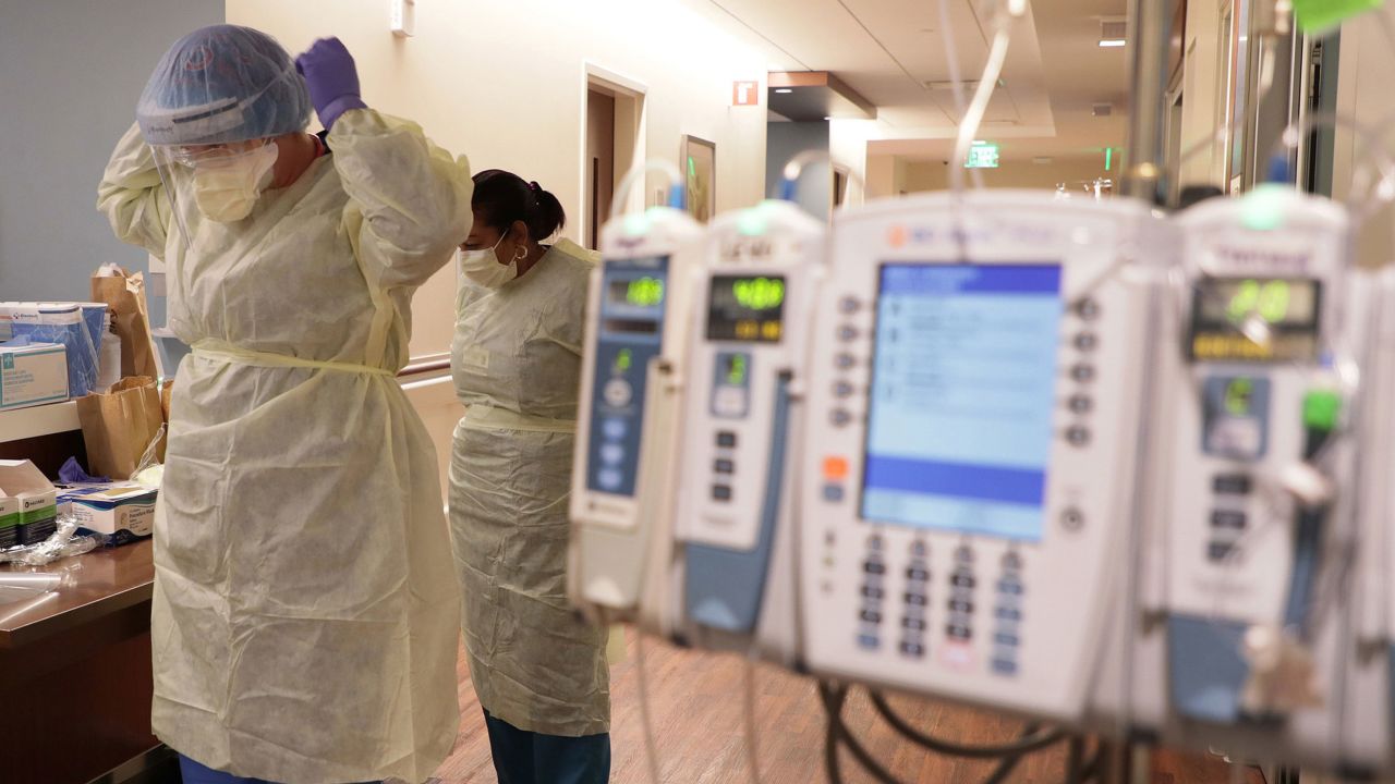 Hospital staff don personal protective equipment before entering the room of a Covid-19 patient at the Northwestern Medicine Lake Forest Hospital ICU in Illinois.