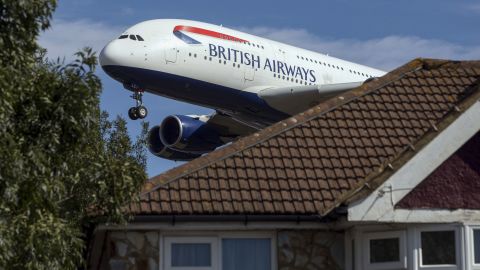 An Airbus SE A380 passenger aircraft, operated by British Airways, a unit of International Consolidated Airlines Group SA (IAG) passes residential rooftops as it prepares to land at London Heathrow Airport in London, U.K., on Friday, Sept. 13, 2019. Climate activists were planning to fly toy drones near Heathrow Friday as part of a campaign to draw attention to an expected increase in greenhouse gas emissions from a planned expansion of the airport.  Photographer: Chris Ratcliffe/Bloomberg via Getty Images