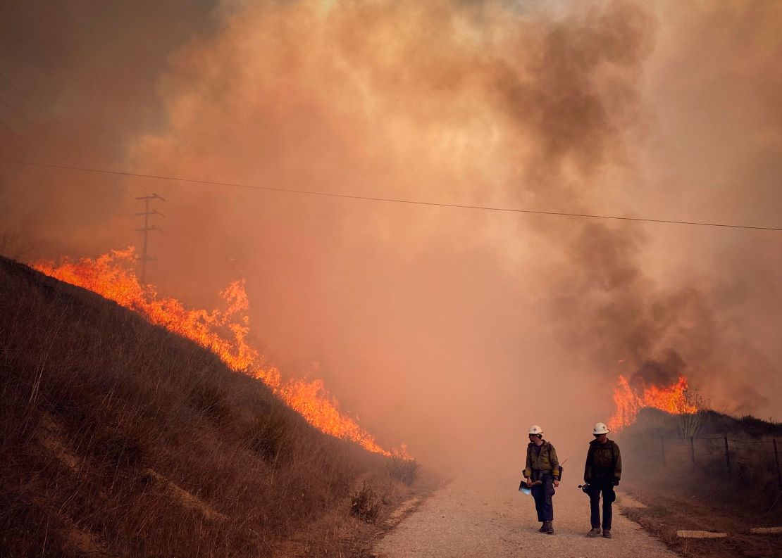 Santa Barbara County Fire Hand Crew members fight fire with fire and burn off pockets of grass along northbound Highway 101 north of Arroyo Hondo Canyon in Santa Barbara County, California, Tuesday.