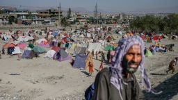TOPSHOT - A man walks past a camp of internally displaced people in Kabul on September 17, 2021. (Photo by BULENT KILIC / AFP) (Photo by BULENT KILIC/AFP via Getty Images)